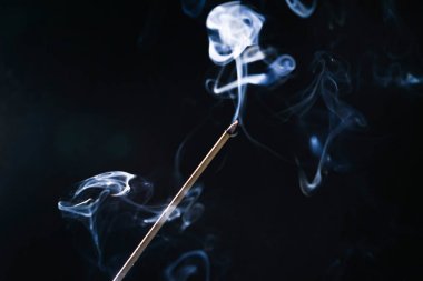 siyah bir arka plan üzerinde smoldering, aromalı sopa çok lezzetli kokuyor