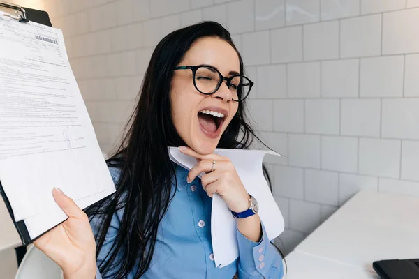 happy busy business woman in glasses freelancing, holding documents in hands