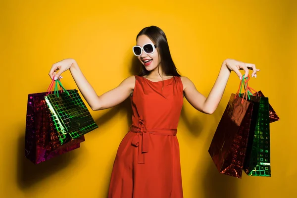 Ein junges stylisches Mädchen mit Sonnenbrille mag den Black Friday, ging einkaufen, kaufte viele Geschenke für das neue Jahr — Stockfoto