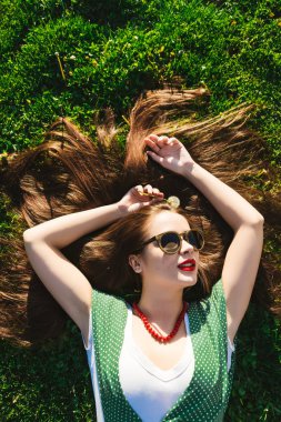 Mutlu yaz gülümseyen kadın rahatlatıcı park, güneş gözlüğü, sağlıklı dişler