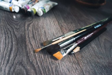 bir ahşap yüzeye tüpleri yağlı boya ve sanatsal fırçaların farklı boyutlarda ile yalan