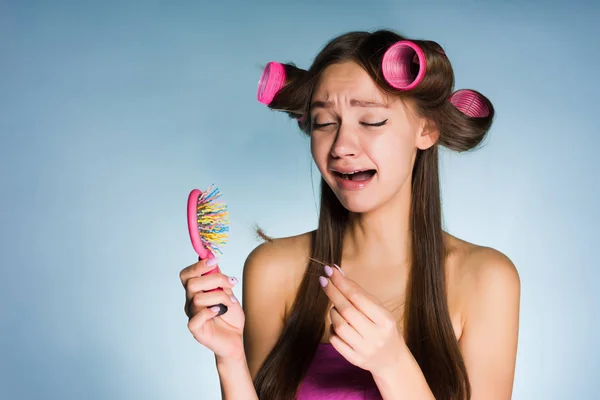 Θλιβερή νεαρό κορίτσι κλαίει, χάνει τα μαλλιά, κρατώντας μια χτένα — Φωτογραφία Αρχείου