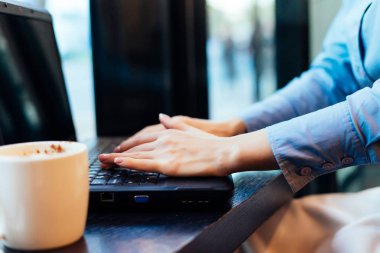 hoş kokulu kahve yanında bir kafede bir dizüstü bilgisayar için çalışan kız serbest meslek