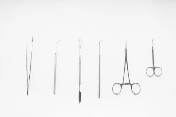 Sur la surface blanche sont des instruments dentaires médicaux — Photo