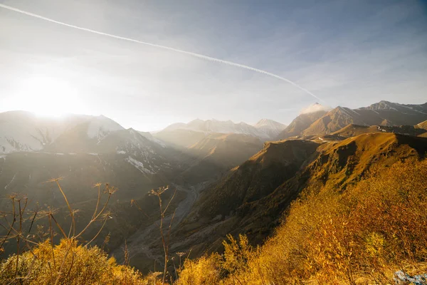 Una vista suggestiva delle alte montagne innevate al sole del mattino, tanto verde — Foto Stock