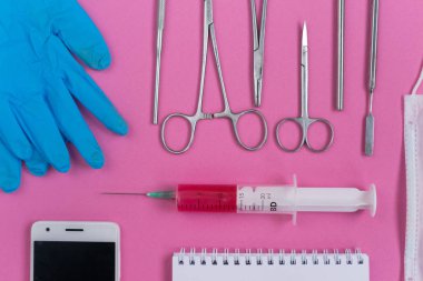 pembe yüzeyde mavi Medikal Ürünler, diş aletleri, bir smartphone ve bir defter vardır