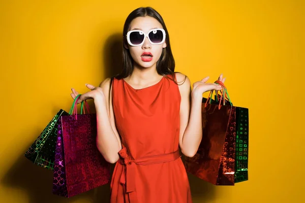Überraschte junge Frau mit Sonnenbrille suchte an einem schwarzen Freitag Geschenke für das neue Jahr — Stockfoto