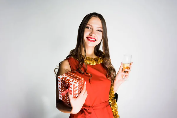 Šťastná dívka v červených šatech se raduje v novém roce 2018, obdržela dar, drží sklenku šampaňského — Stock fotografie