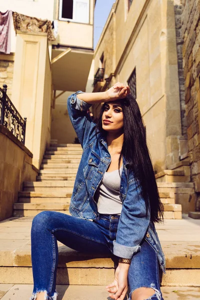 Fashionable long-haired girl tourist posing on the stairs in the ancient city of Baku — Stock Photo, Image