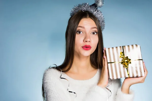 Удивлена молодая девушка получила подарок на новый год, на голове праздничный колпак — стоковое фото