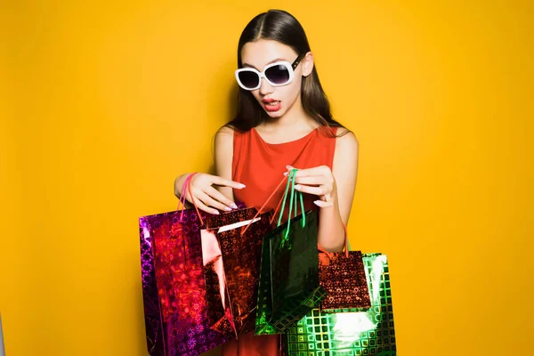 Zabawna dziewczyna w okulary kupił dużo prezenty na nowy rok na czarny piątek — Zdjęcie stockowe