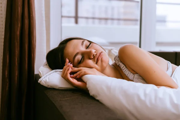 Fiatal gyönyörű lány alszik az ágyban, ő egy nap — Stock Fotó