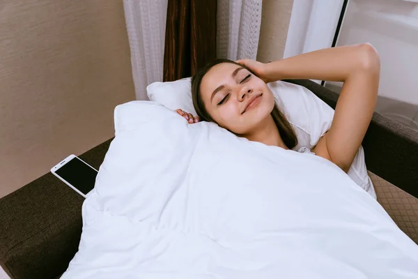 Boldog fiatal lány fekszik az ágyban, nem akar felkelni, ő egy nap — Stock Fotó