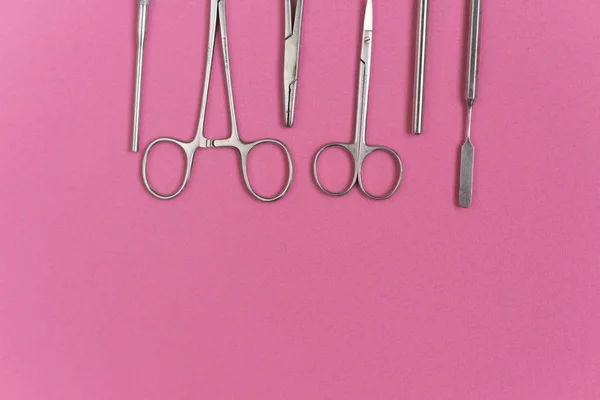 Na superfície rosa são instrumentos odontológicos médicos, tesoura — Fotografia de Stock