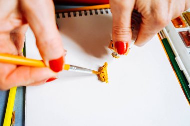 beyaz kağıt üzerine bir fırça kadın ressam boyalar