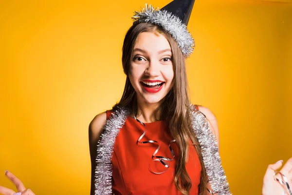 Laughing happy girl in a red dress, with a silver tinsel around her neck celebrating the new year 2018 — Stock Photo, Image