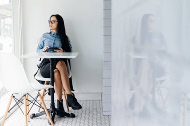 Üniversitede Dersler sonra kafede oturan gözlüklü genç düşünceli kız öğrenci