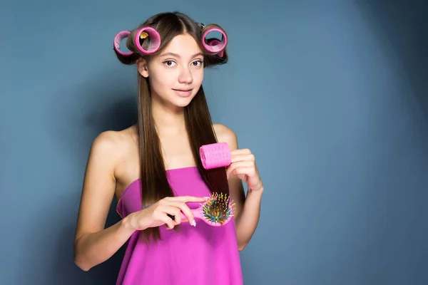 Όμορφη κοπέλα με μακριά μαλλιά κάνει ένα μοντέρνο χτένισμα με σίδερα — Φωτογραφία Αρχείου