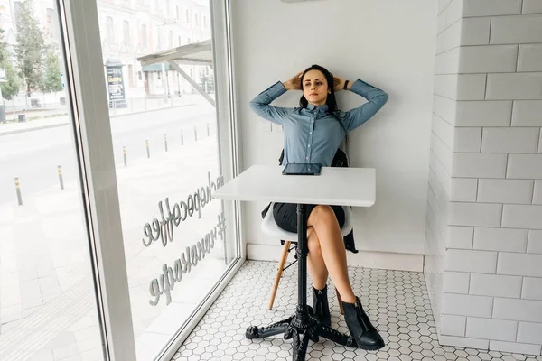 Jeune étudiante assise à une table dans un café — Photo