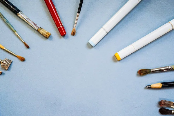 På blå ytan är konstnärliga tillbehör, penslar och pennor — Stockfoto