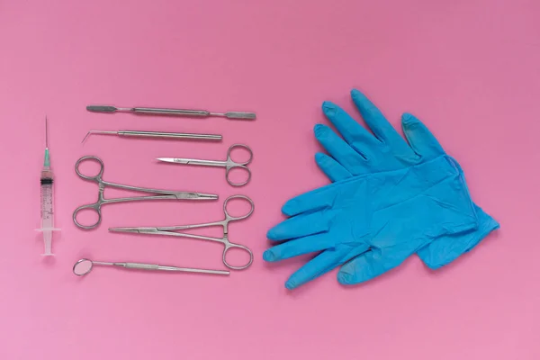 핑크색 표면에는 치과 의료 기기 및 파란색 장갑 — 스톡 사진