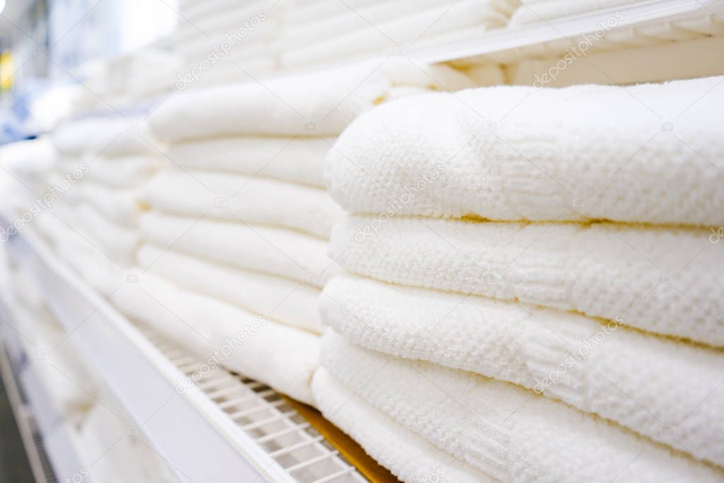 on the rack are many white terry towels for the bath
