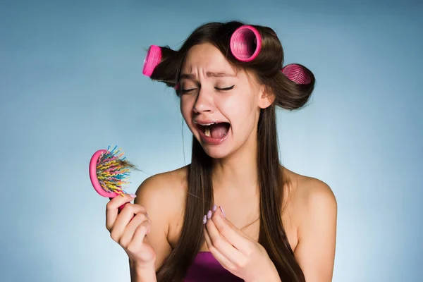 Молодая девушка хотела сделать красивую прическу с бигуди, но теряет волосы и плачет — стоковое фото