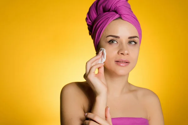 Beautiful girl cares about her beauty, cleans the skin on her face with a cotton disc — Stock Photo, Image