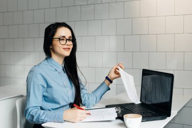 mutlu esmer iş kadını bardaklarda laptop ve kafede belgelerle çalışma