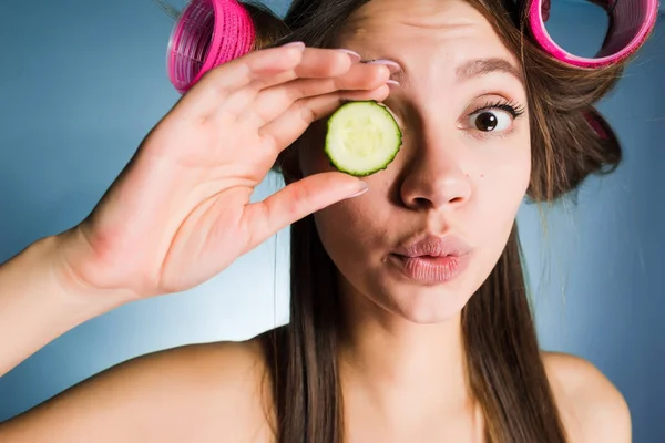 Komik bir salatalık yüzü, yakındaki bir parça curlers kafasına tutan kız şaşırttı — Stok fotoğraf