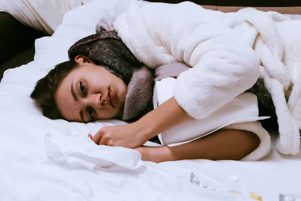 침대, 그녀의 목, 목 주위에 따뜻한 스카프에에서 있다 슬픈 어린 소녀는 매우 아픈 — 스톡 사진