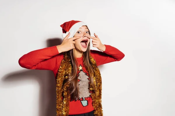 Αστείο κορίτσι δείχνει στα δάχτυλα στη μύτη, στα γιορτινά ρούχα σε αναμονή για το νέο έτος 2018 — Φωτογραφία Αρχείου