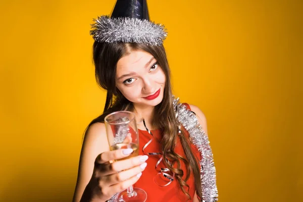 Молодая красивая девушка празднует Новый год, держит в руках бокал шампанского и хочет выпить — стоковое фото