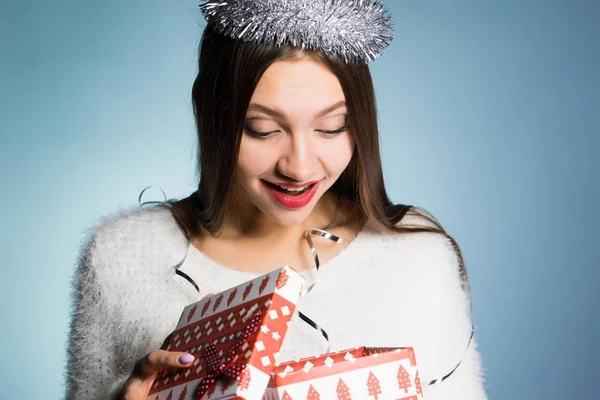 Glückliches junges Mädchen erhielt ein Geschenk für das neue Jahr, schaut in die Geschenkbox — Stockfoto