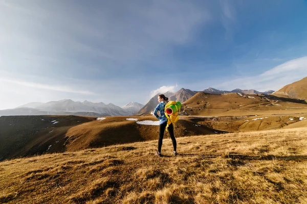Egy fiatal, Aktivál lány a kék kabát utazik a kaukázusi hegygerincen élvezi természet és a tiszta levegő — Stock Fotó