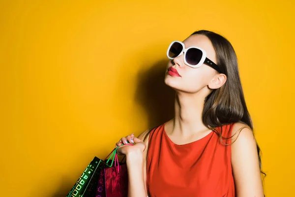 Bela jovem em óculos de sol adora fazer compras, comprou um monte de coisas, em um centavo preto — Fotografia de Stock