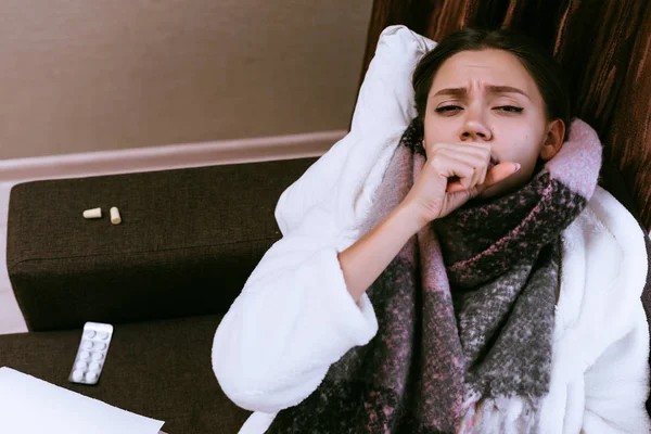 Грустная молодая девушка заболела больным горлом из-за холодной погоды, теплый шрам на шее, кашель — стоковое фото
