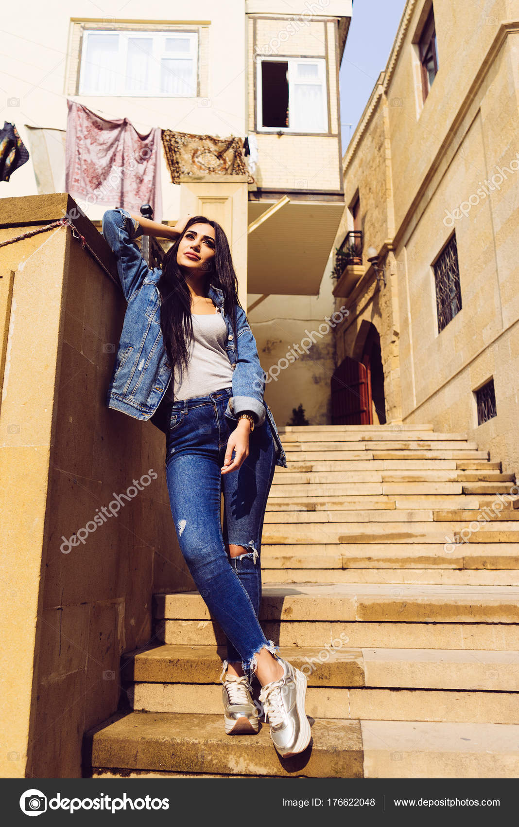Stylish long-haired girl in jeans clothes travels on vacation
