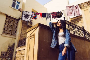 şık siyah saçlı kız pitoresk eski mimarisi fonunda poz Azerbaycan seyahat