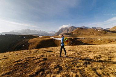 mavi bir ceket ve bir sırt çantası ve bir çadır sırtında dağ havası gidiyor bir aktif genç kız Gezgin