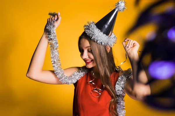 Счастливая девушка в красном платье держит серебряную мишуру празднует новый 2018 год — стоковое фото