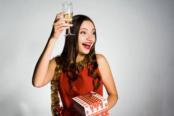 Счастливая красивая девушка празднует новый 2018 год, держит в руке бокал шампанского и подарок — стоковое фото