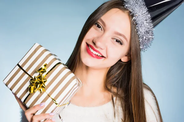 Glücklich lächelndes Mädchen mit festlichem Hut erhielt ein Neujahrsgeschenk von ihren Kollegen — Stockfoto