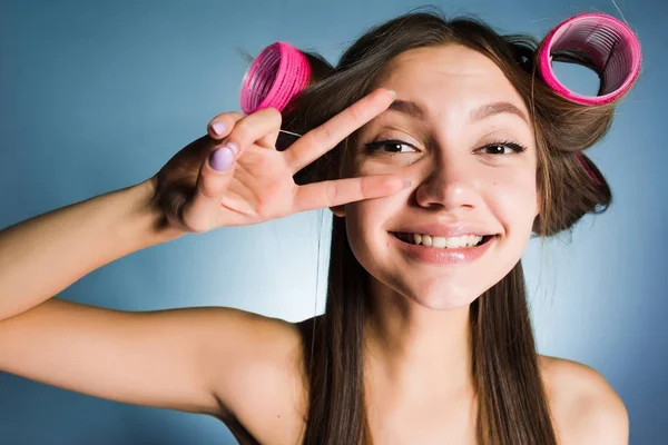 Счастливая красавица показывает два пальца на голове керлингиста — стоковое фото