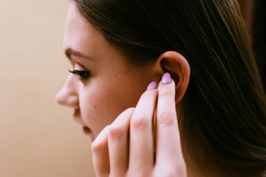Genç bir kız onun ears kulak tıkacı sokak gürültü karşı koyar