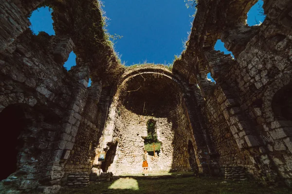 Stylisches junges Mädchen reist und posiert in einer antiken Bauruine — Stockfoto