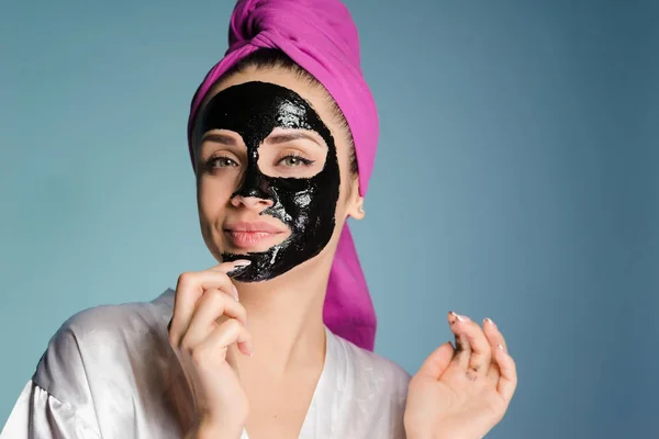 Sorrindo jovem quer pele limpa em seu rosto, colocou uma máscara preta contra pontos pretos — Fotografia de Stock
