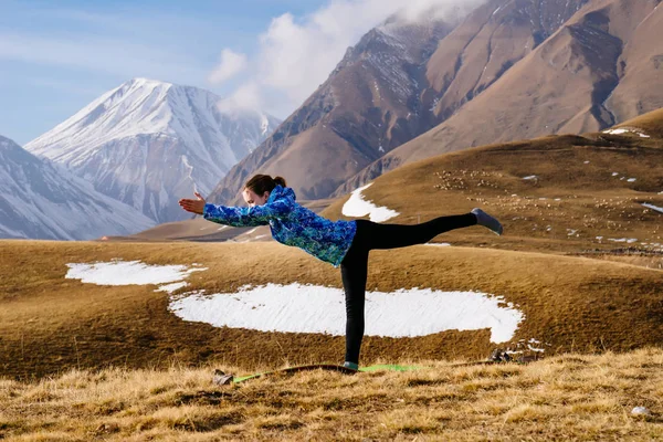 Счастливая девушка, занимающаяся йогой на фоне Кавказских гор, ведущая активный образ жизни — стоковое фото