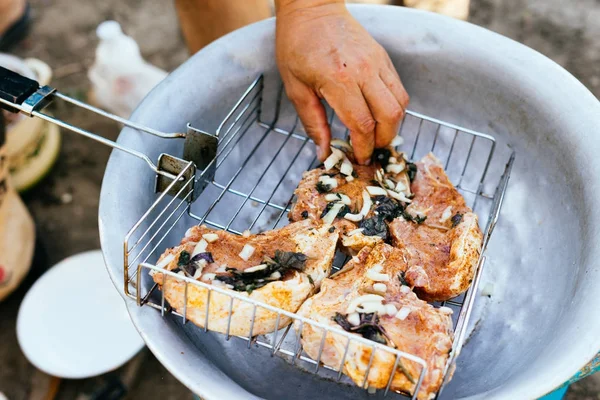 Egy ember szakácsok nyers szarvas húst egy piknik a természetben — Stock Fotó