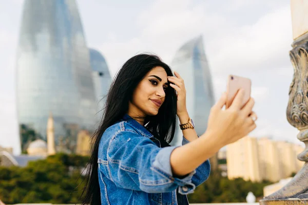 Hermosa chica de pelo negro viaja a través de Europa, hace selfie en un fondo de arquitectura moderna — Foto de Stock